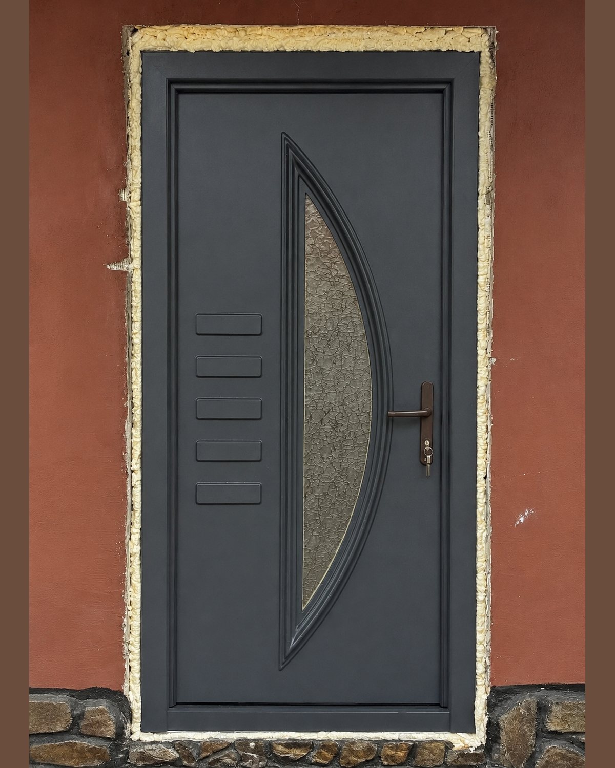 SK14T anthracite door panel with textured glazing, installed on a terracotta façade